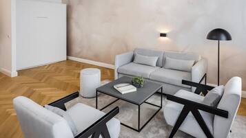 Una sala de estar moderna con un sofá gris, una mesa de centro y una lámpara de pie.