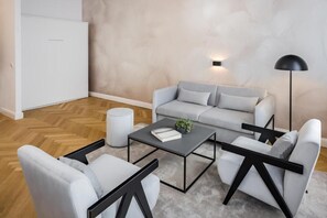 Una sala de estar moderna con un sofá gris, una mesa de centro y una lámpara de pie.