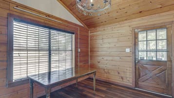 A room with wooden walls, a bench, a door, and a window with blinds.