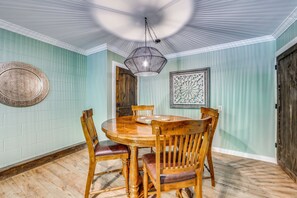 A dining area with a round wooden table, four chairs, a hanging light fixture, and decorative wall art. - Cold Mountain Cabin W/hot Tub, Pool Table & Views (Canton)