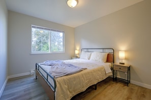 A bedroom with a single bed, a bedside table with a lamp, a window with blinds, and a ceiling light. - 3 Mi to Olympia! Apt w/ Shared Laundry (Lacey)