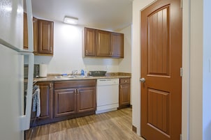 Una cocina con armarios de madera, lavavajillas y refrigerador.