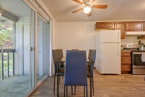 A modern kitchen with a refrigerator, stove, and wooden cabinets. There is a dining area with a table and chairs. - 12 Mi to Jblm: Olympia-area Escape (Lacey)