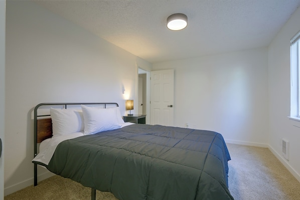 A bedroom with a single bed, a nightstand, a lamp, and a door leading to another room. - Centrally Located Lacey Escape: 2 Mi to Hospital (Lacey)