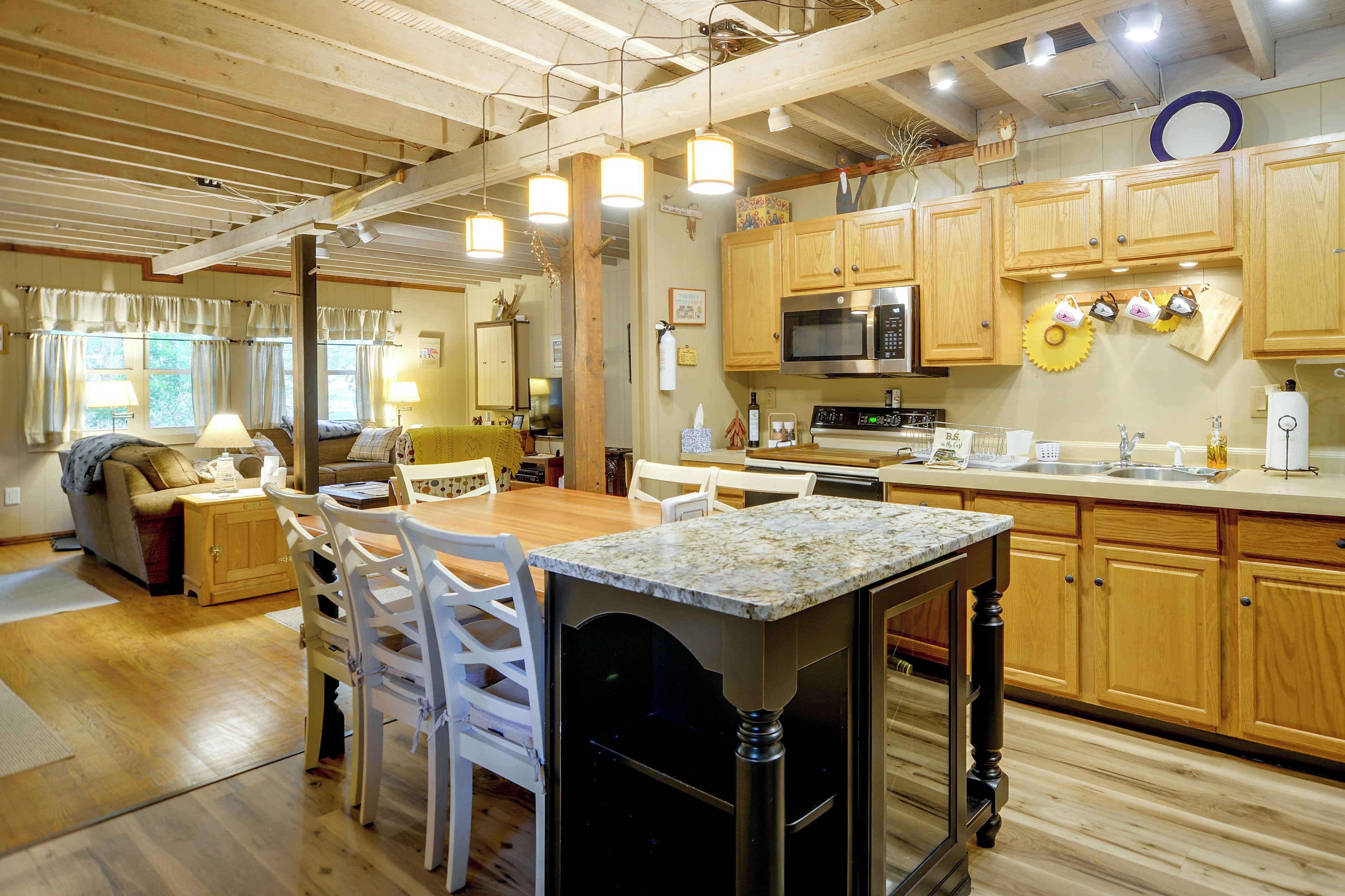 A spacious kitchen with wooden cabinets, a central island, and a dining area with chairs.