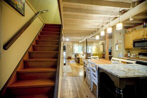A staircase leading to a living area with a kitchen and dining space. - Pet-friendly w/ Dock & Fenced-in Yard in Swanton (Swanton)