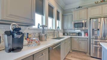 A modern kitchen with stainless steel appliances, a dishwasher, and a microwave.