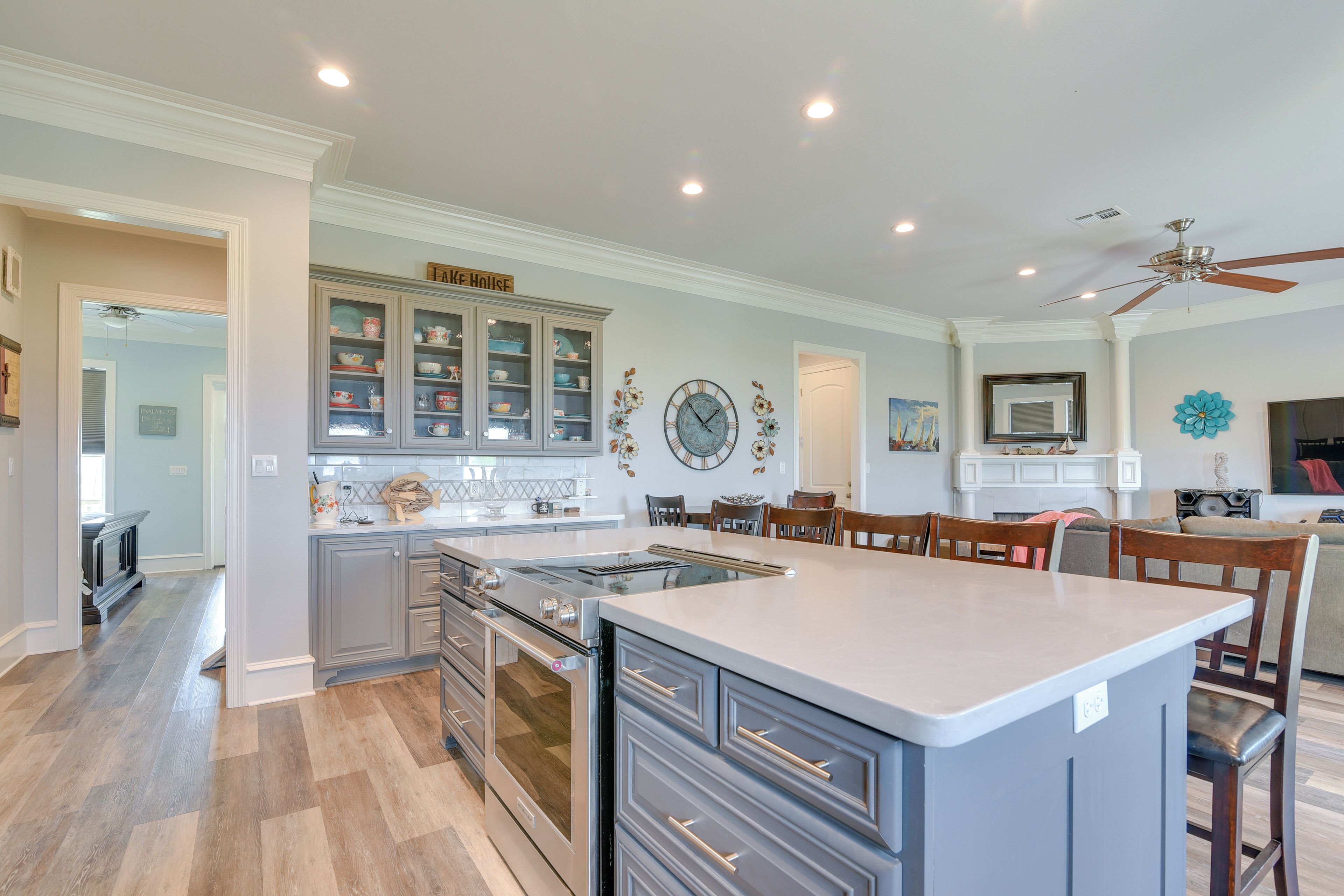 A modern kitchen with a central island, built-in appliances, and a dining area with chairs and a table.