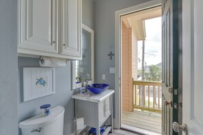 A bathroom with a toilet, sink, and blue basin. - Sabine Lake Waterfront Retreat W/700' Lighted Pier (Port Arthur)