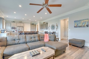 A spacious living room with a sectional sofa, a coffee table, and a ceiling fan. - Fishing Pier, Wraparound Deck: Sabine Lake Home (Port Arthur)