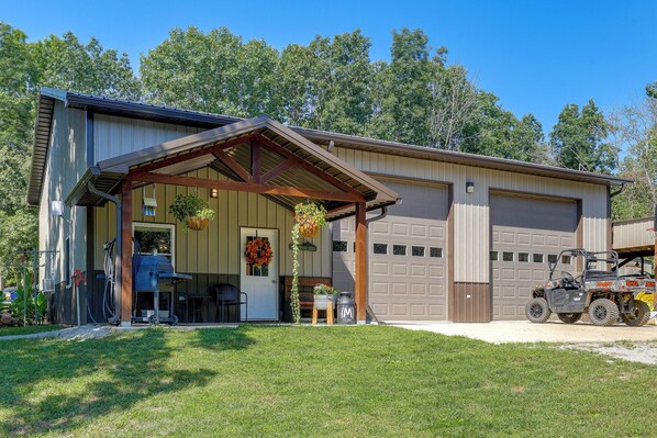 A building with a covered entrance, a garage, and a vehicle parked outside.