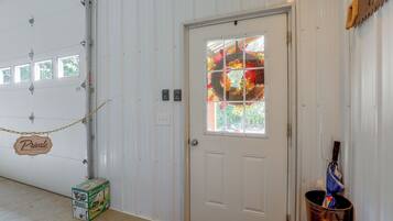 A garage door with a 'Private Please Do Not Enter' sign, a window with a decorative wreath, and a bucket with a blue tarp.