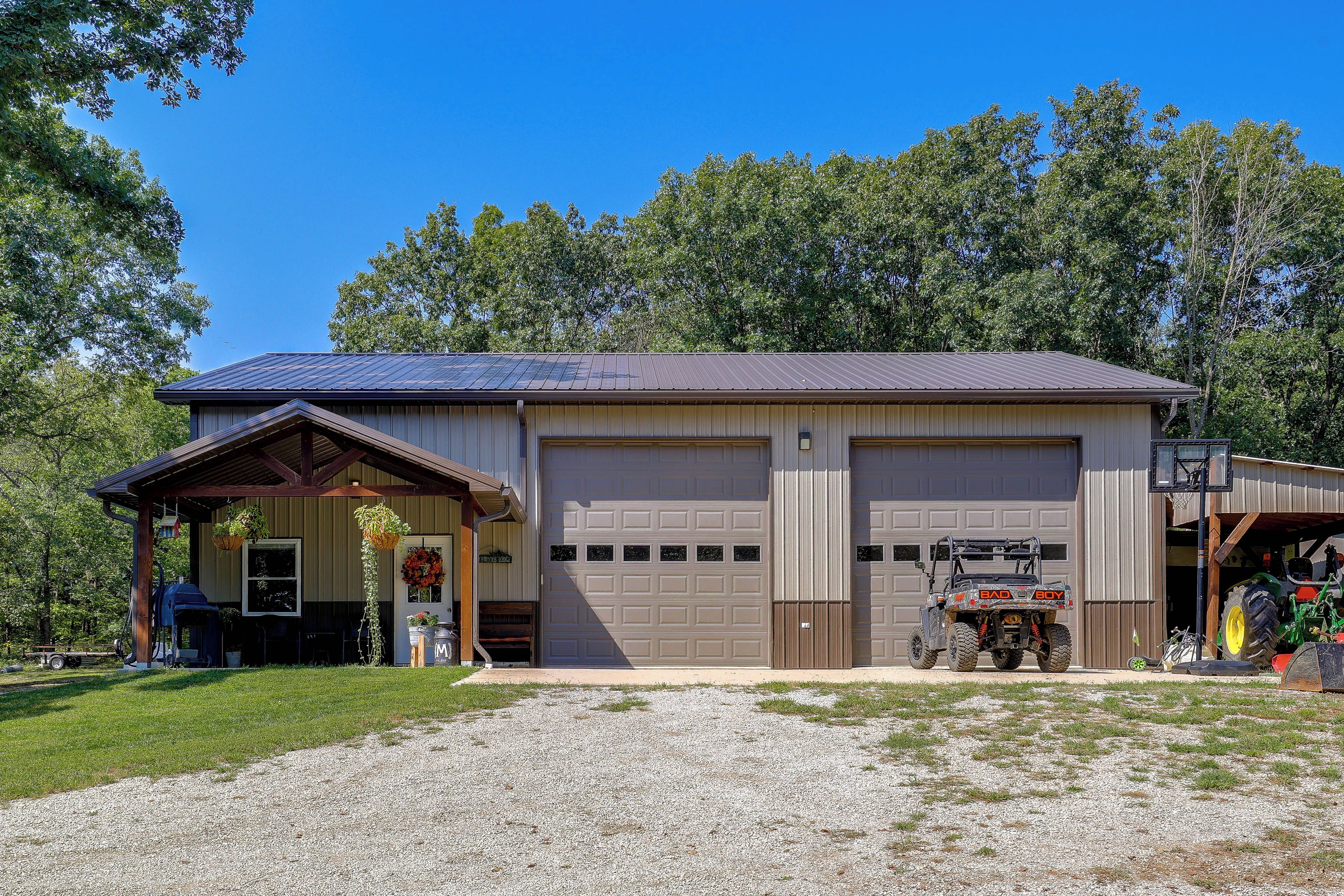 A two-story building with a garage, a covered porch, and a basketball hoop.