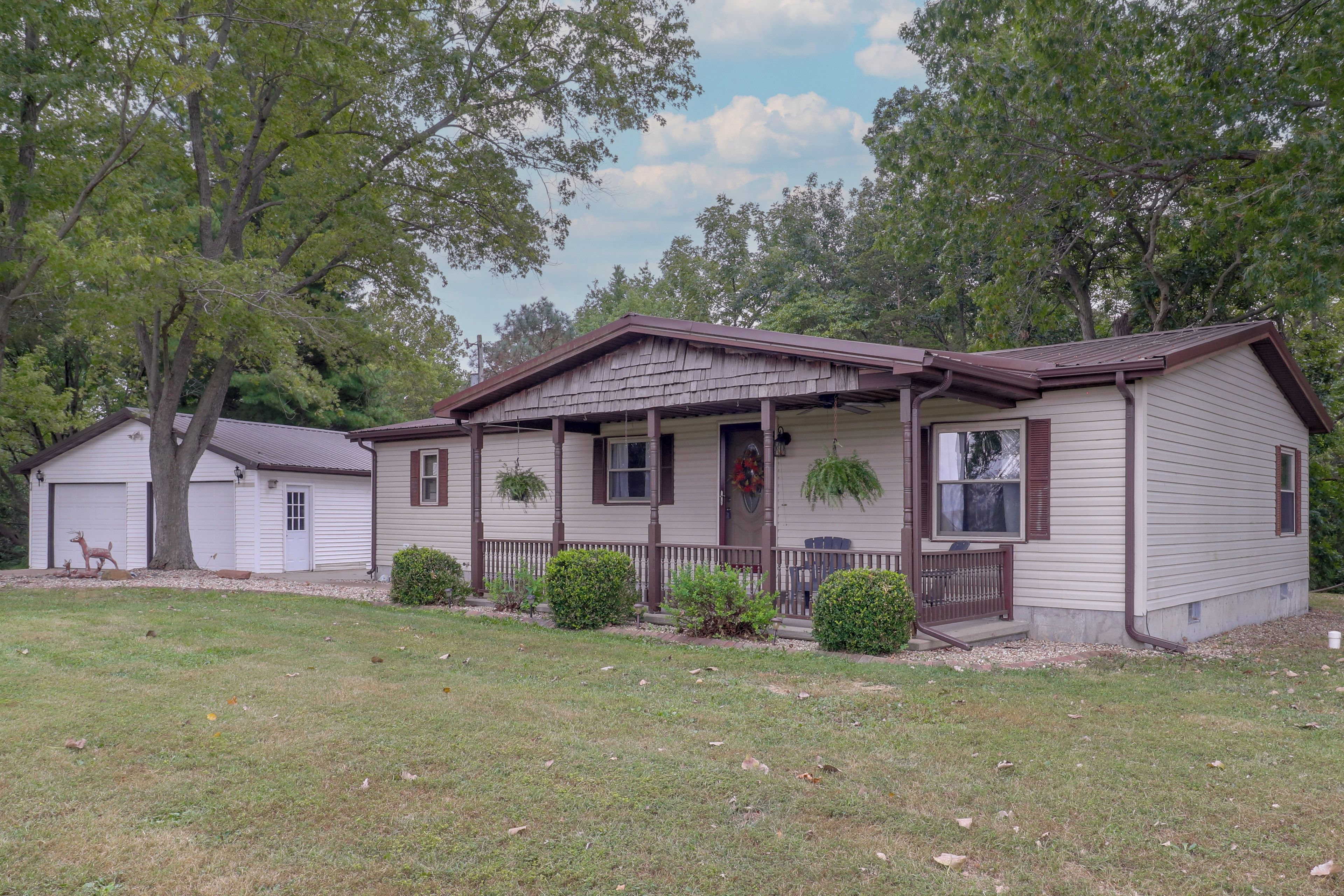 A single-story house with a porch, a garage, and a small yard.