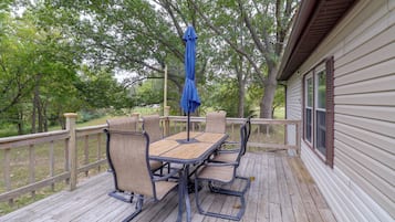 A wooden deck with a table and chairs, surrounded by a wooden railing.
