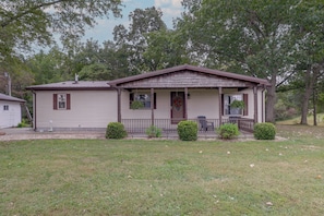 A single-story house with a front porch, a small attached garage, and a well-maintained lawn.