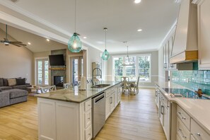 A spacious kitchen with a large island, modern appliances, and pendant lighting.