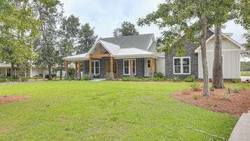 A residential house with a stone facade, a covered porch, and a well-maintained lawn.