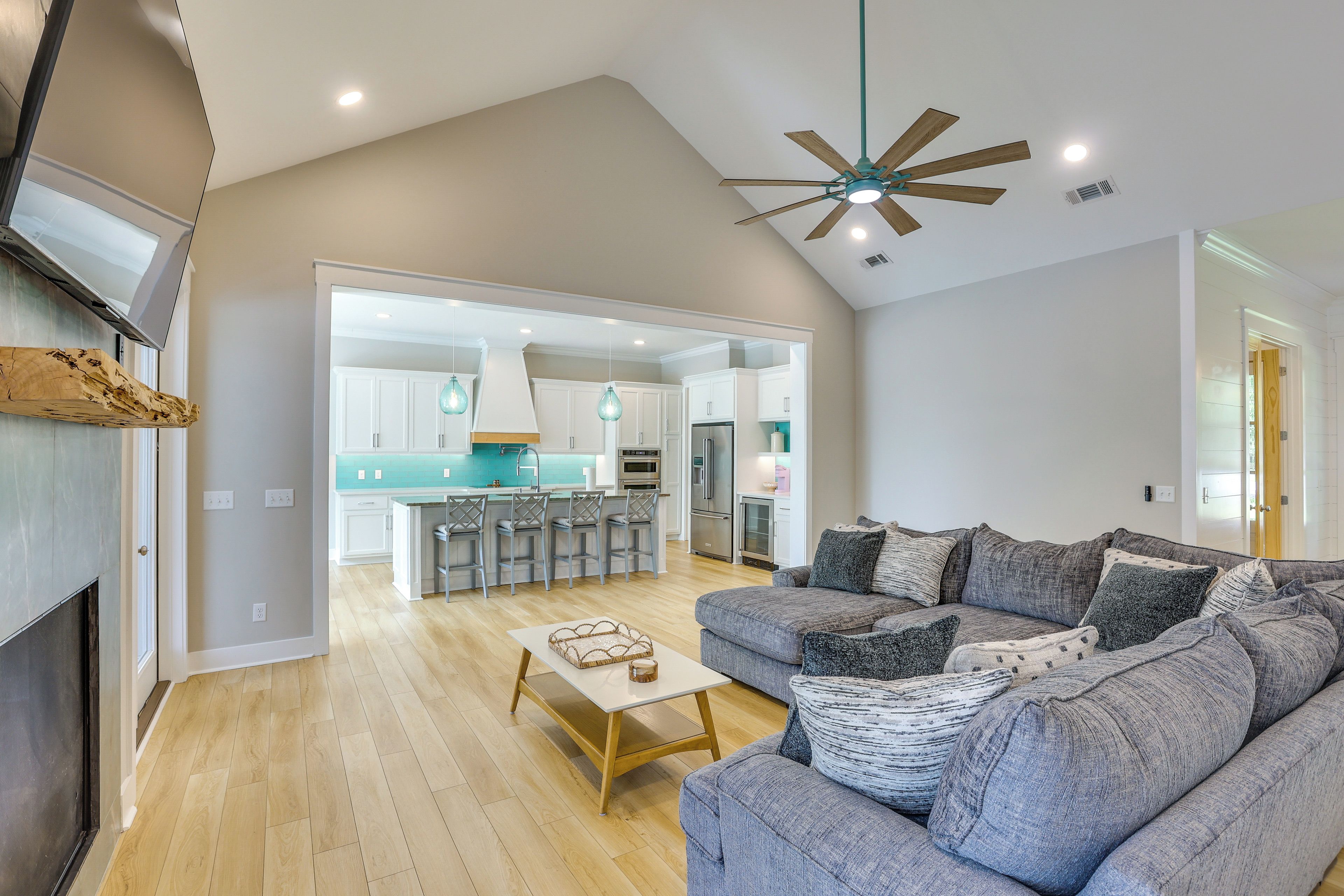 A modern living room with a sofa, coffee table, and a ceiling fan.