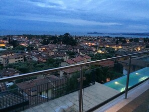 A residential area with a pool, houses, and a distant view of the sea. - Holiday Home 'Aurora Elegant Lake View' with Lake View, Shared Pool and Wi-Fi (Toscolano Maderno)