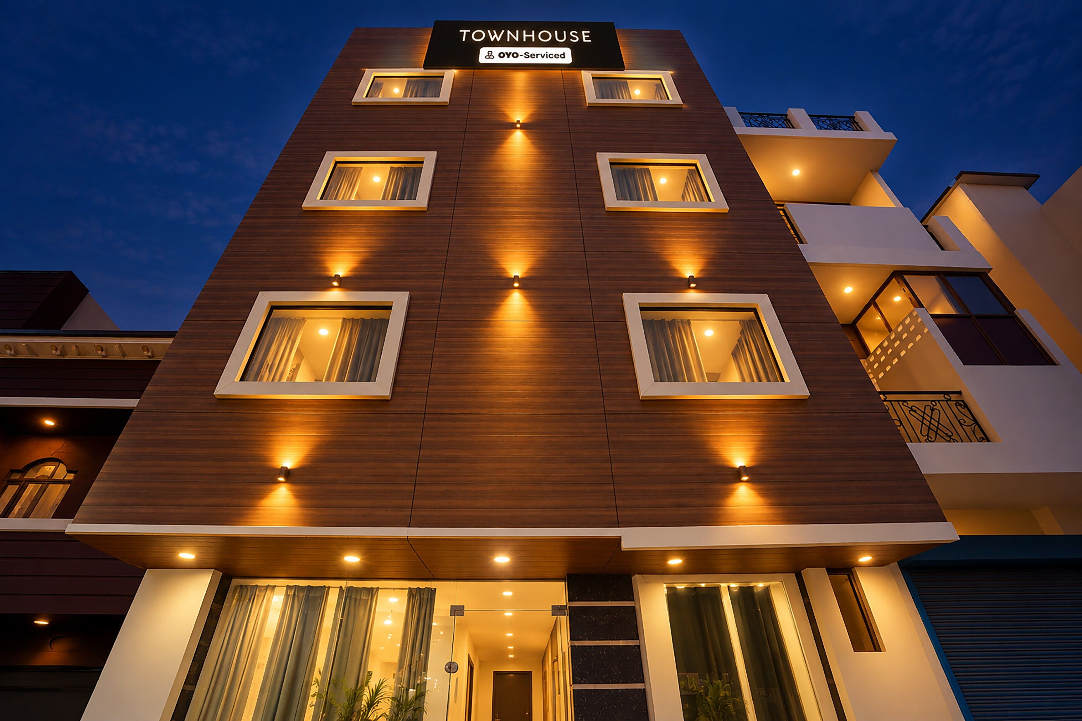 A modern townhouse with a sign indicating it is serviced by OYO.