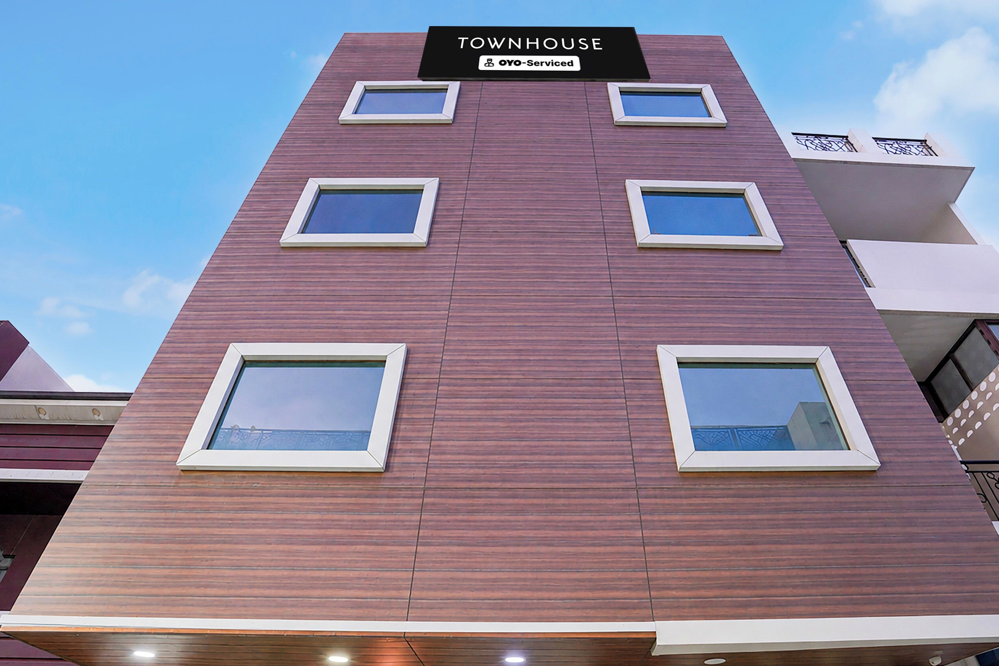 A multi-story building with a sign reading 'TOWNHOUSE YOYO-Serviced'.