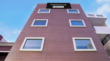 A multi-story building with a sign reading 'TOWNHOUSE YOYO-Serviced'.