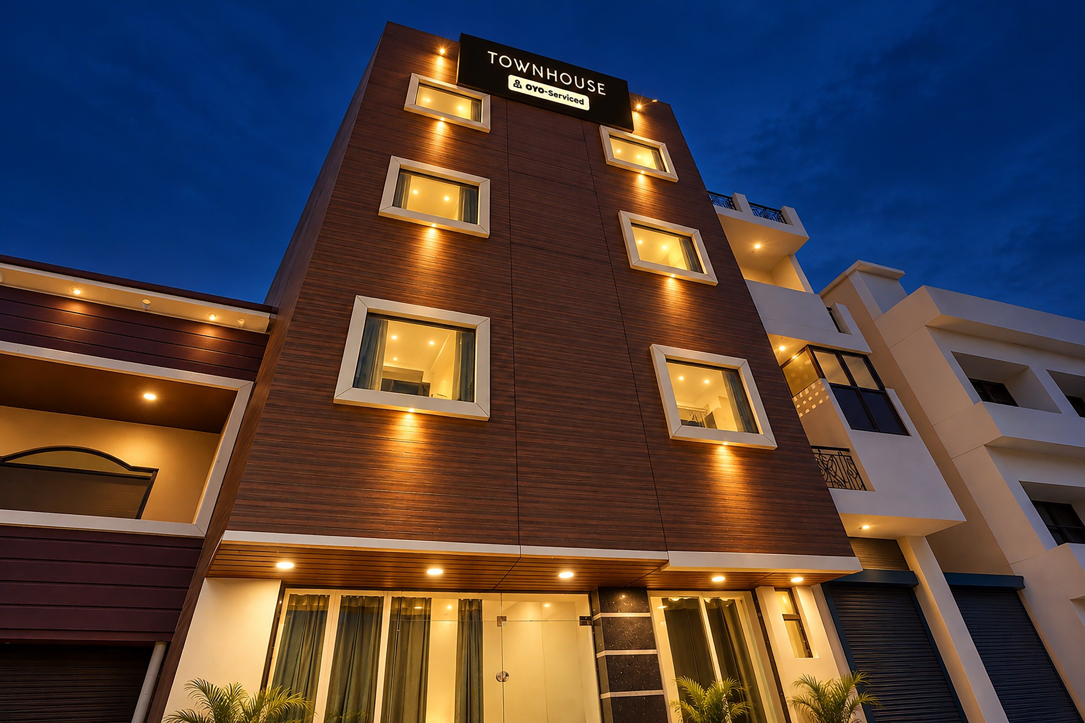A multi-story building with a sign reading 'Townhouse' and 'Oyo-Serviced'.