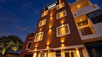 Un hotel de varios pisos con diseño moderno, que muestra un cartel que dice 'TOWNHOUSE' y 'OYO-Serviced'.