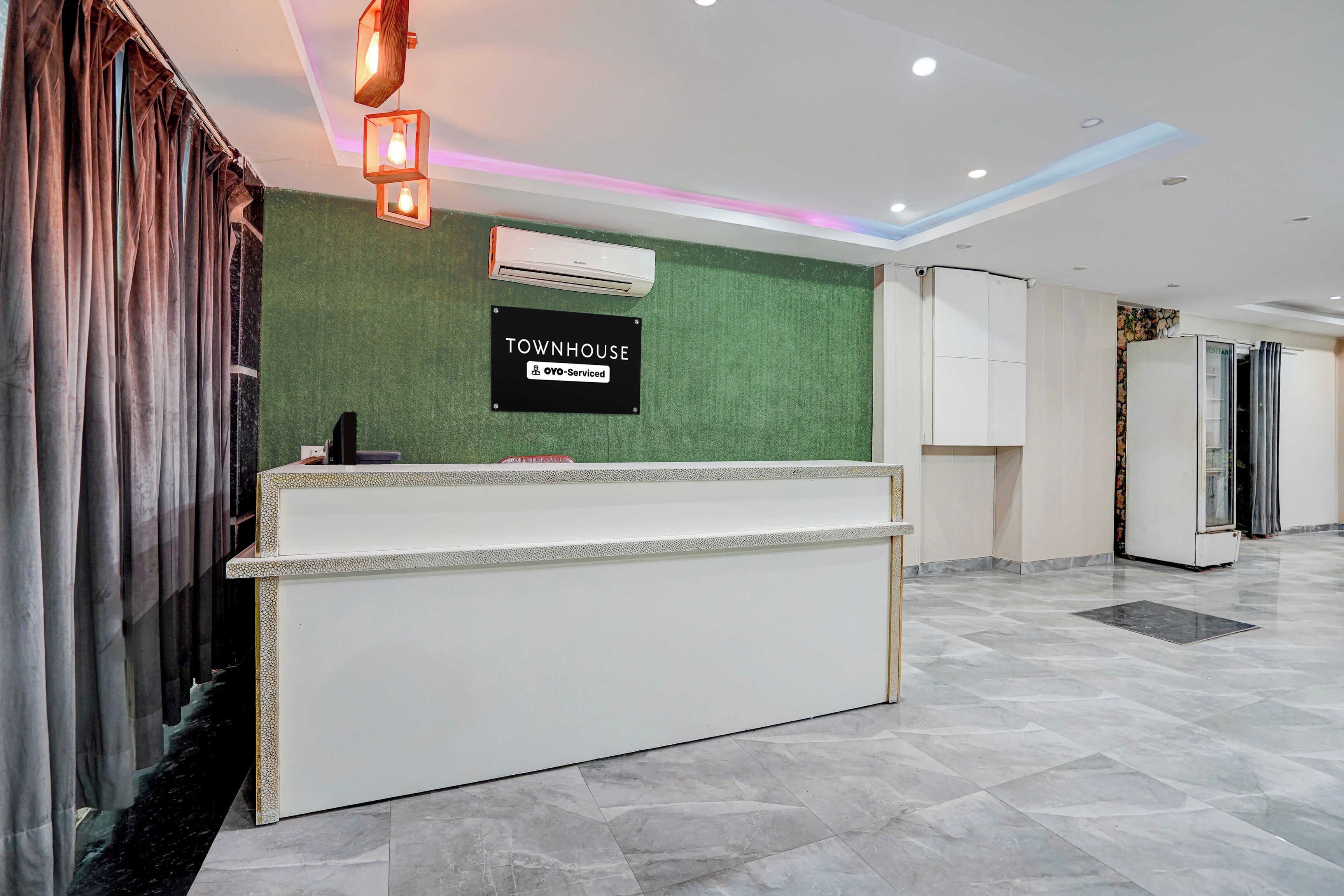 Una recepción con un cartel que indica 'Townhouse' y 'OYO-Serviced'.