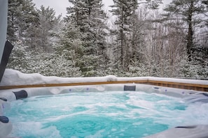 A hot tub surrounded by snow-covered trees. - Stay at the Ski Hive close to Sunday River (Newy)