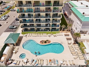 Hotel de diversos pisos amb piscina al terrat, zona de seients a l'aire lliure i aparcament.