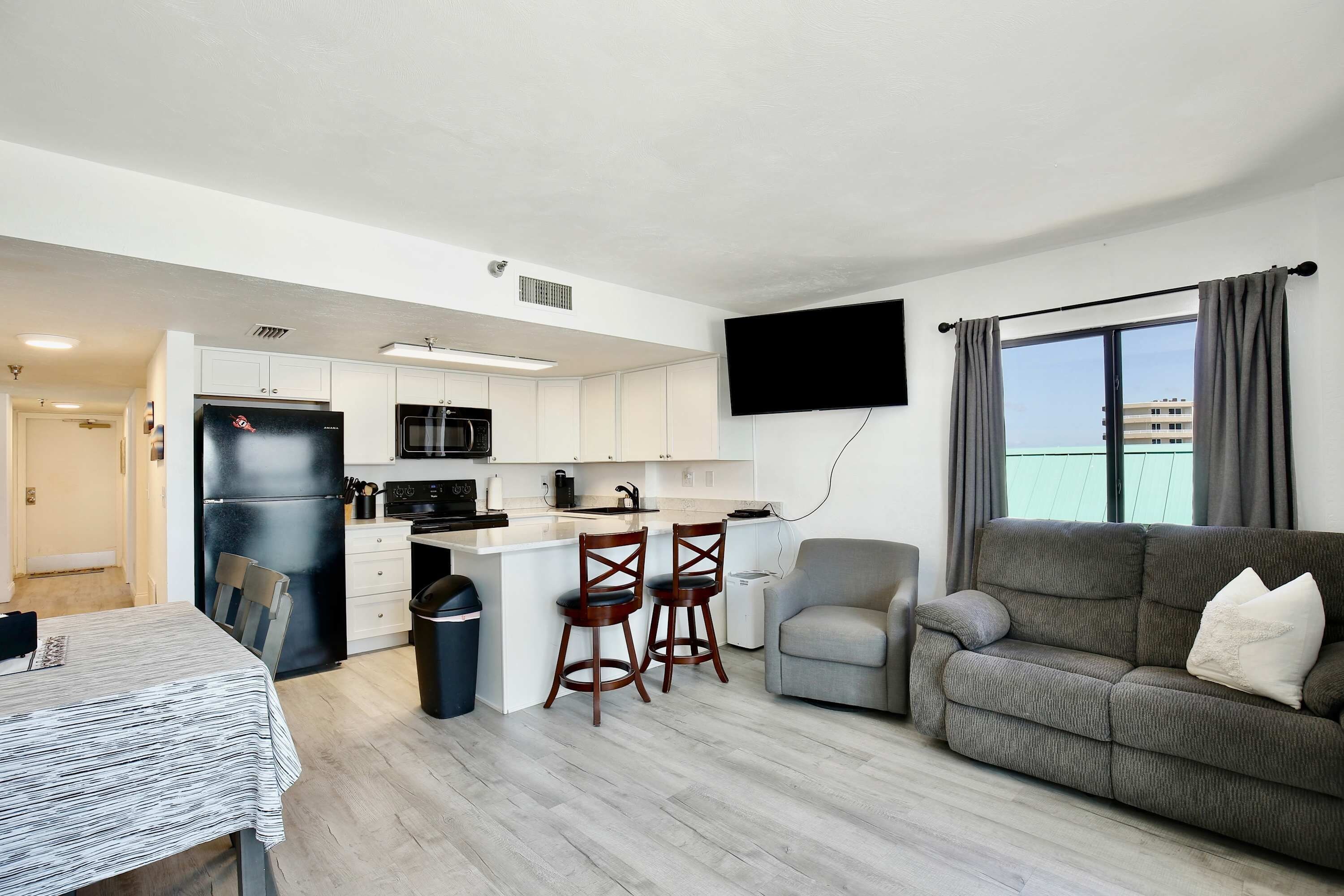 Un appartement moderne comprenant une cuisine, un coin repas et un salon.