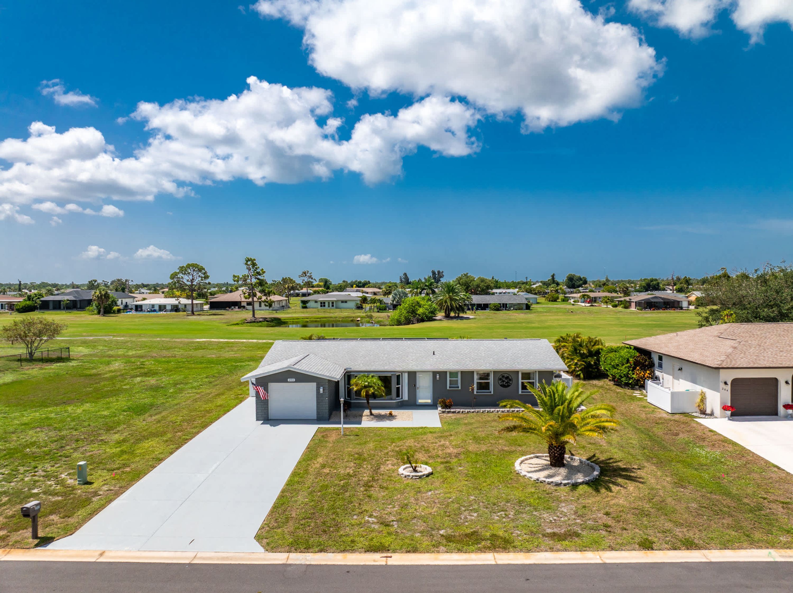 A residential area with houses, a clear sky, and a well-maintained lawn.
