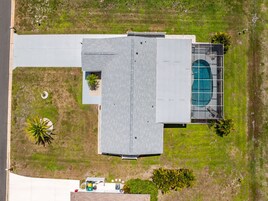 Vista aérea de un edificio con techo plano, piscina y vegetación circundante.