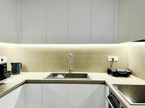 A modern kitchen with a stainless steel sink, a kettle, and a coffee maker. - Boutique stay in Athens center (Athina)