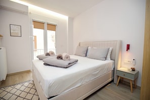 A modern bedroom with a large bed, a bedside table with a lamp, and a window with blinds. - Boutique stay in Athens center (Athina)