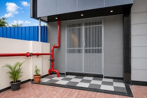 A building exterior with a checkered floor, a gated entrance, and red pipes. - Townhouse Star Square Vijay Nagar Indore (Indore)
