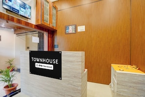 A reception area with a 'TOWNHOUSE' sign, a security camera, and a wooden wall. - Townhouse Star Square Vijay Nagar Indore (Indore)