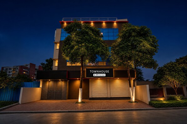 A modern townhouse with a closed garage door, a sign indicating it is serviced by OYO, and a well-lit entrance. - Townhouse Star Square Vijay Nagar Indore (Indore)