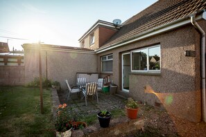 A residential backyard with a patio, outdoor seating, and potted plants. - Warrack Street (No 37) | St Andrews (St Andrews)