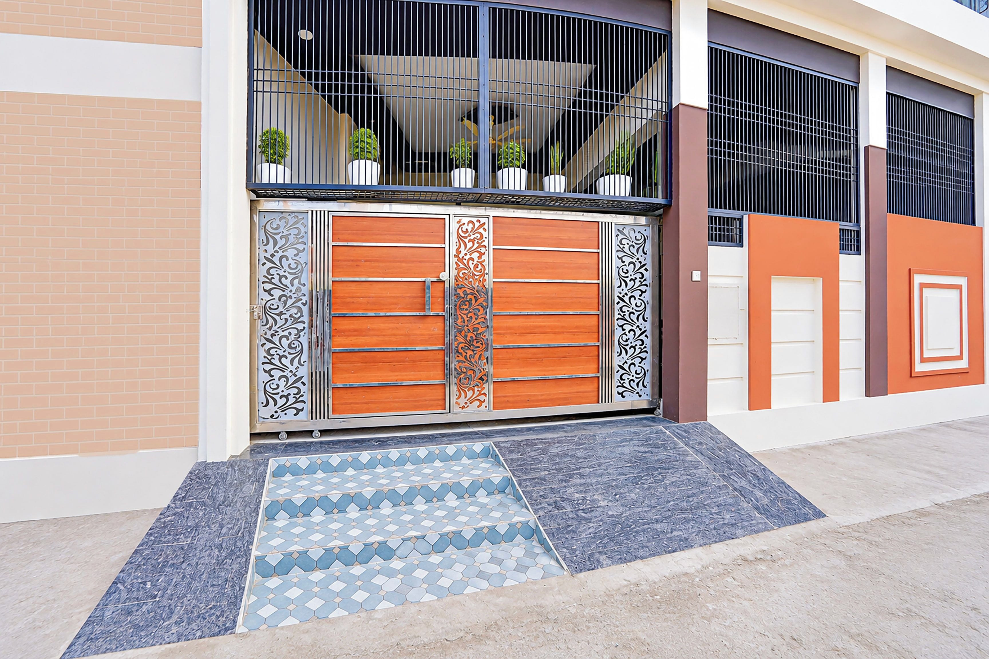 Una entrada cerrada con una verja metálica decorativa y un felpudo estampado.