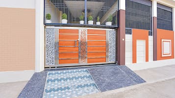 Una entrada cerrada con una verja metálica decorativa y un felpudo estampado.