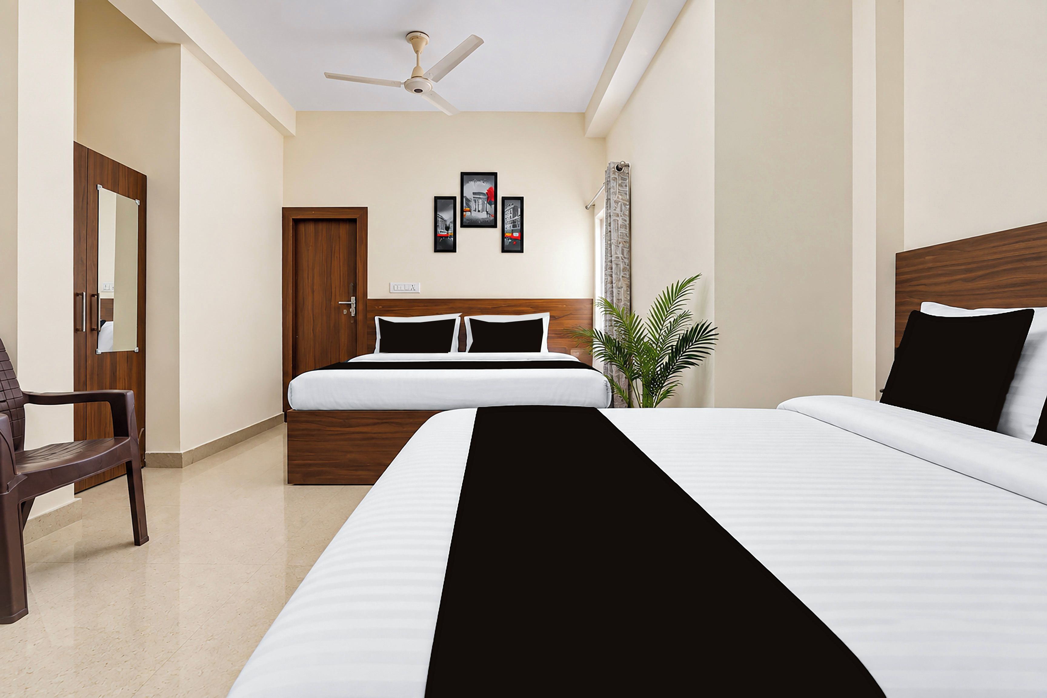 A hotel room with a bed, a chair, a ceiling fan, and a door.