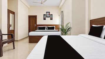 A hotel room with a bed, a chair, a ceiling fan, and a door.