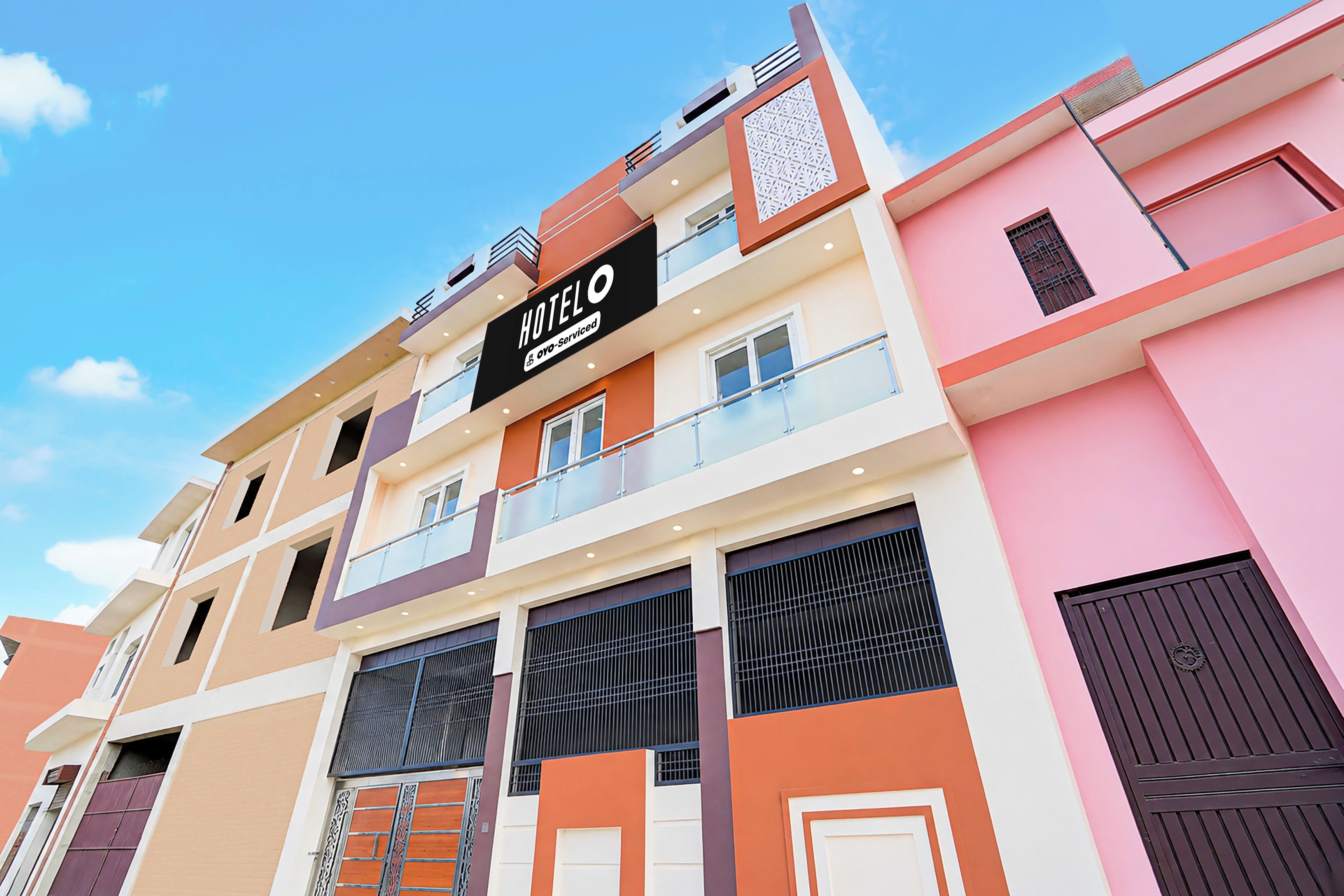 Un hotel de varios pisos con un llamativo letrero que dice 'HOTEL', balcones y un diseño arquitectónico moderno.