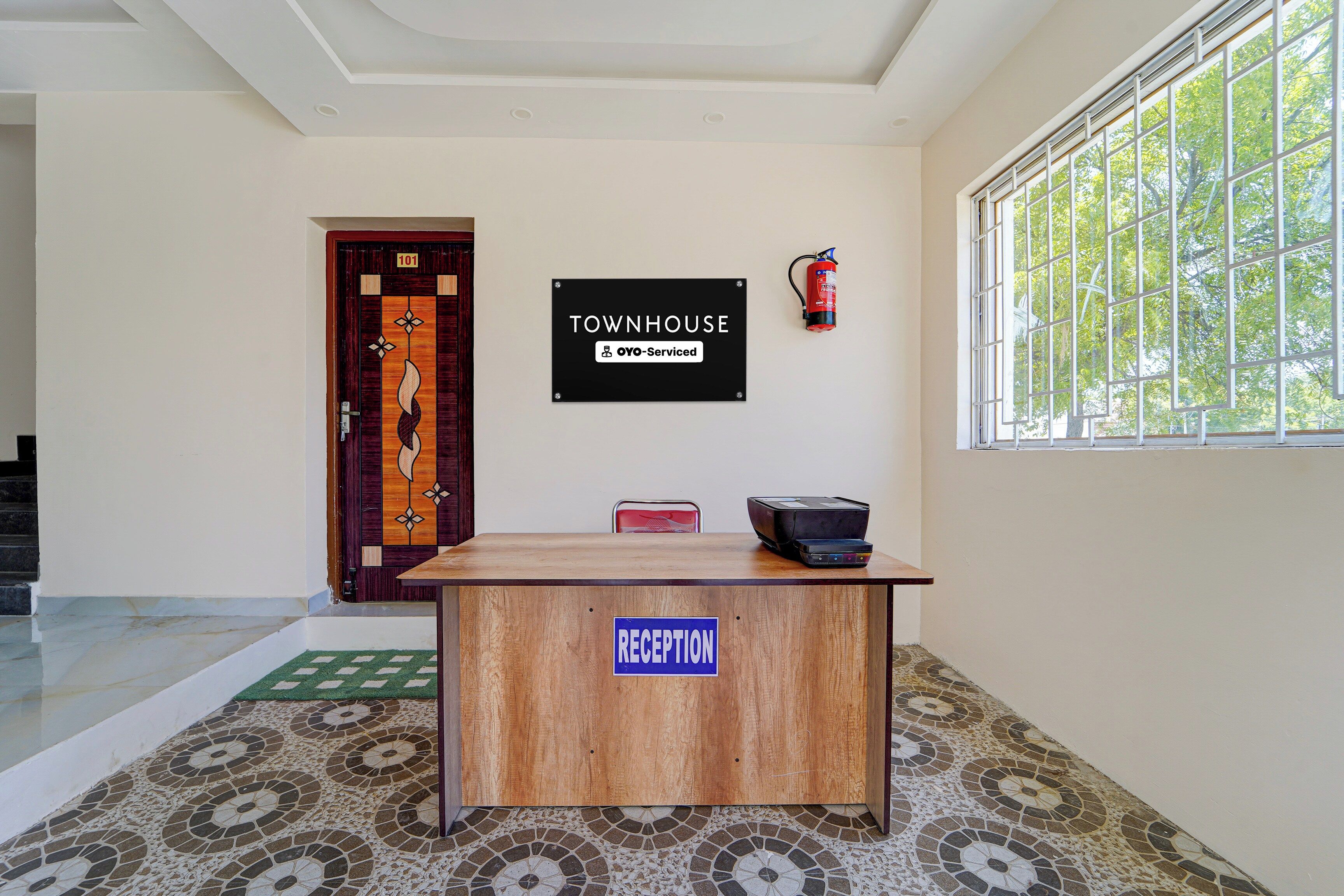 Una mesa de recepción con un cartel que indica que se trata de una casa de campo gestionada por OYO.