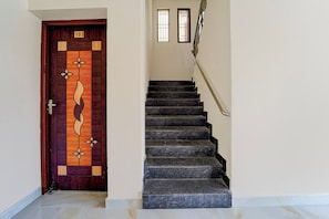 A staircase with a wooden door marked with the number 103. - Townhouse Mattuthavani (Madurai)