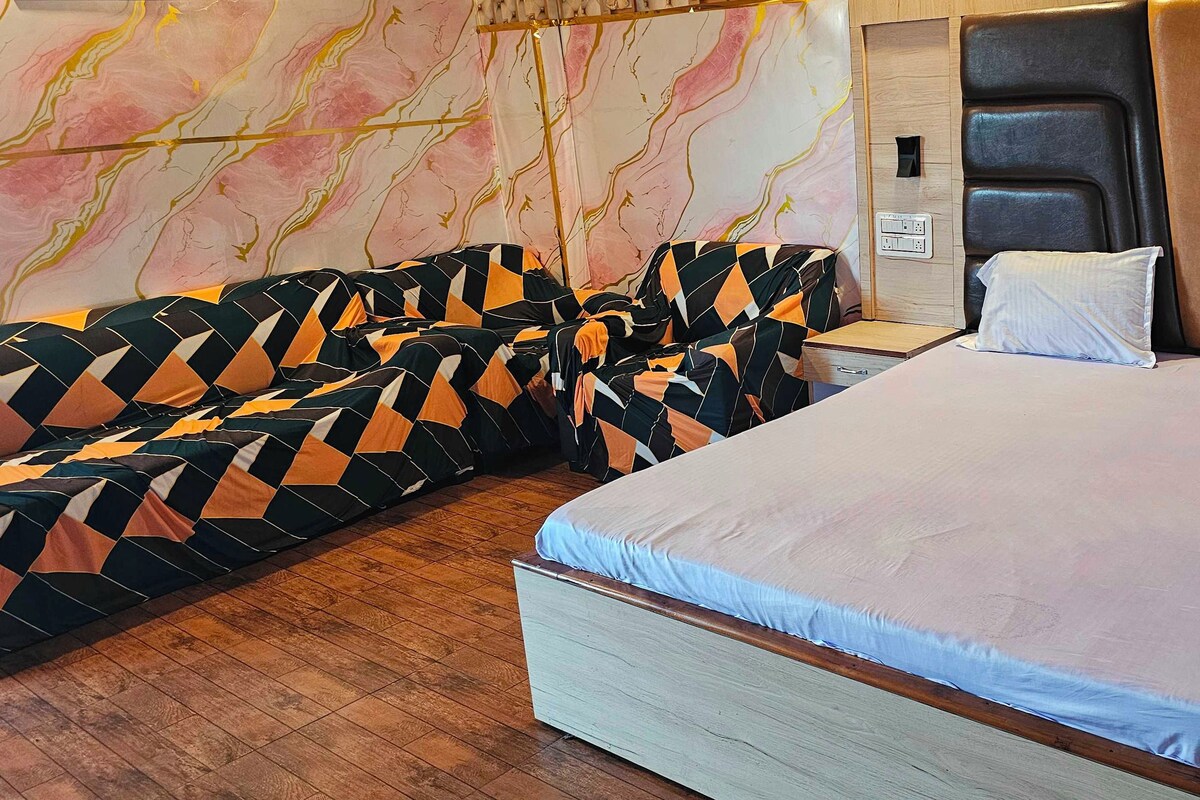 Habitación de hotel con cama, sofá y pared con diseño de mármol.