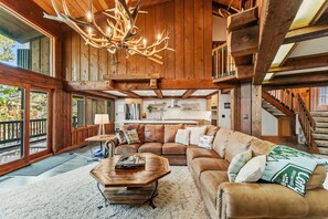 A spacious living room with a large wooden ceiling, a leather sofa, and a coffee table. - Silverthorne Mountain Retreat Hot Tub Sauna Near Keystone Breck and Copper (Silverthorne)